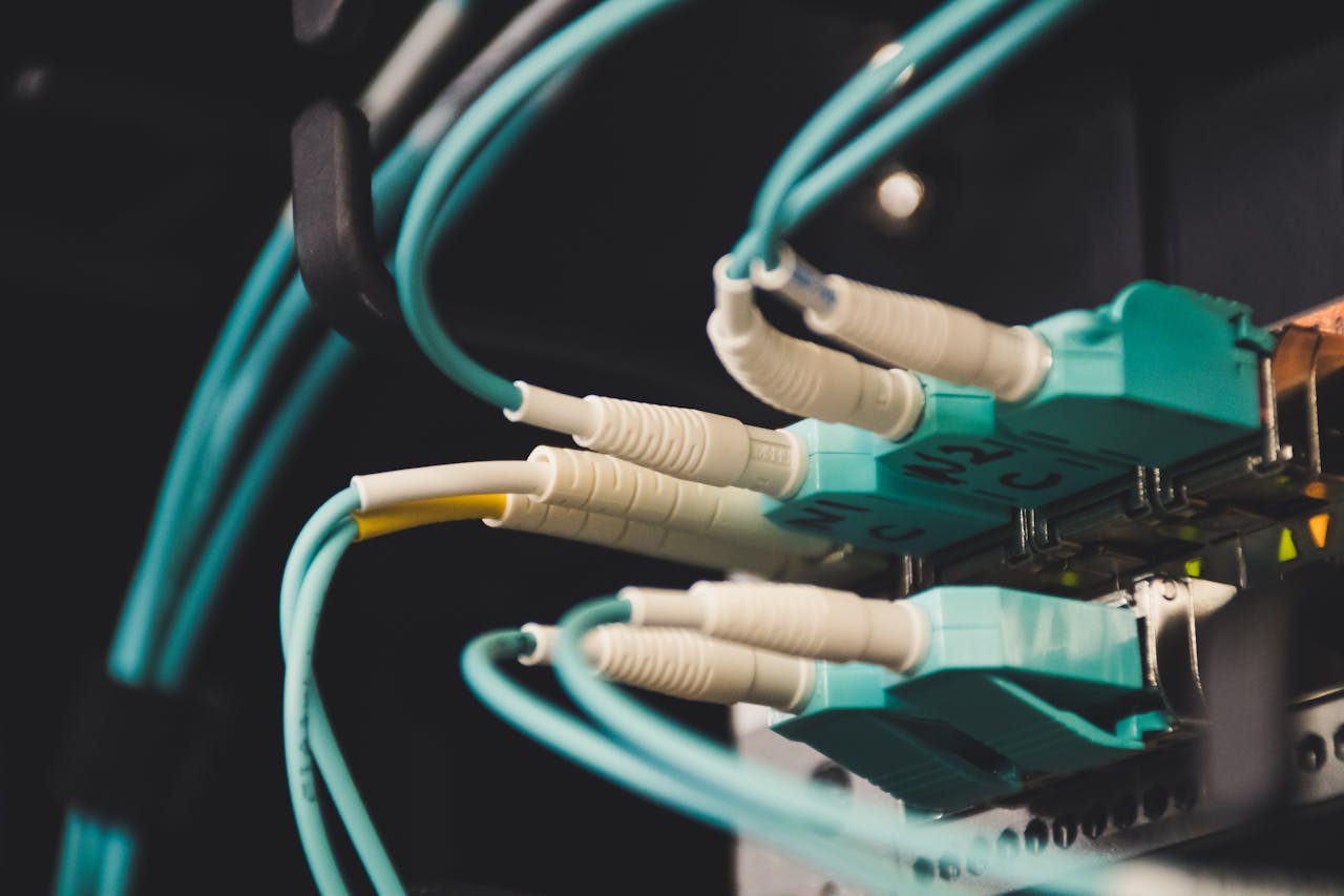 services-02 Detailed view of fiber optic cables and ports in a server room, showcasing connectivity.