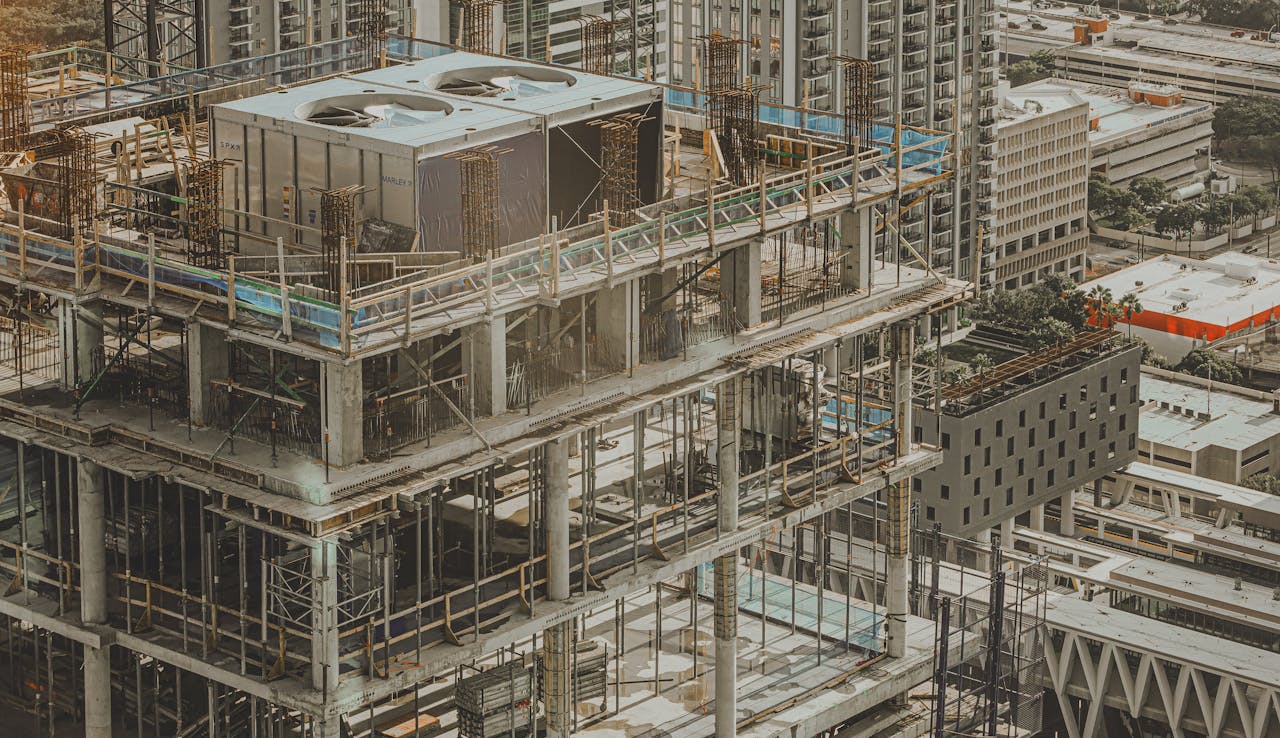 hero-img-01 Aerial view of a high-rise building under construction in a bustling city environment.